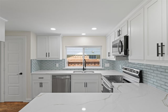 1315 Dunbarton Dr, Richardson, TX 75081 - kitchen featuring appliances with stainless steel finishes, light stone counters, white cabinets, decorative backsplash, and recessed lighting