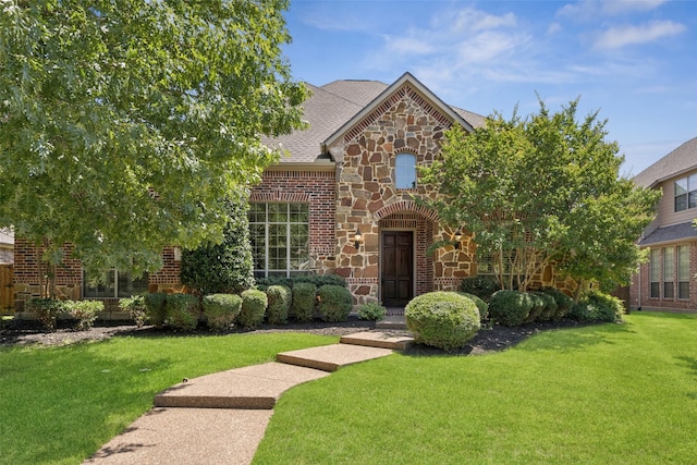 1316 Comal Dr, Allen, TX 75013 - view of front of house with stone siding, a front yard, brick siding, and a shingled roof
