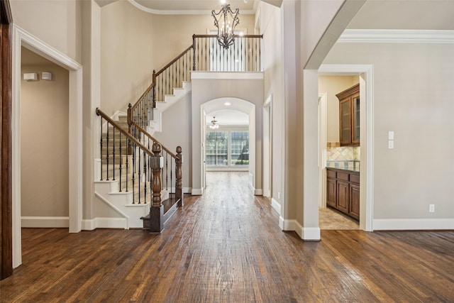 1316 Comal Dr, Allen, TX 75013 - foyer entrance featuring dark wood-type flooring, a chandelier, crown molding, stairway, and arched walkways