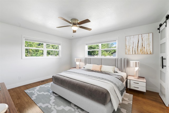 3501 Alta Vista Dr, Waco, TX 76706 - bedroom with a barn door, wood finished floors, and ceiling fan