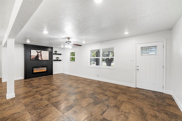 3501 Alta Vista Dr, Waco, TX 76706 - unfurnished living room featuring a fireplace, recessed lighting, ceiling fan, stone finish floors, and a textured ceiling