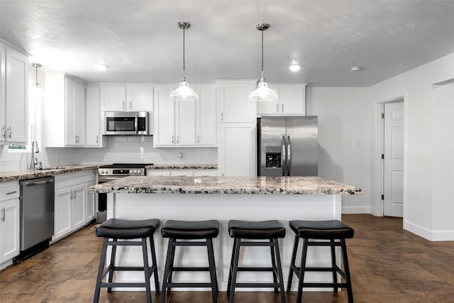 3501 Alta Vista Dr, Waco, TX 76706 - kitchen featuring stainless steel appliances, decorative backsplash, white cabinetry, and a kitchen island