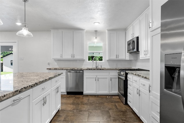 3501 Alta Vista Dr, Waco, TX 76706 - kitchen featuring stainless steel appliances, tasteful backsplash, white cabinetry, hanging light fixtures, and light stone counters
