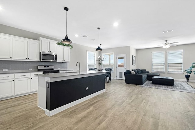 1160 Kirkham Way, Fort Worth, TX 76247 - kitchen with appliances with stainless steel finishes, light wood-type flooring, tasteful backsplash, white cabinets, and recessed lighting