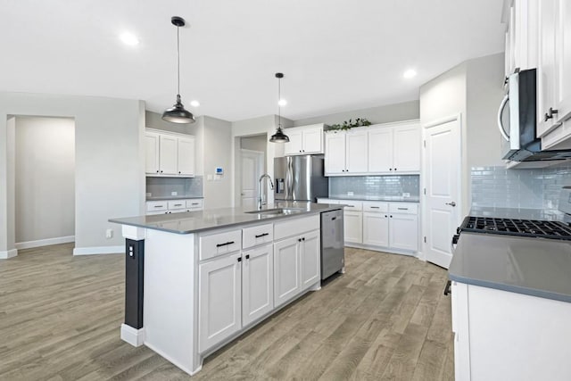 1160 Kirkham Way, Fort Worth, TX 76247 - kitchen featuring stainless steel appliances, light wood-type flooring, tasteful backsplash, recessed lighting, and an island with sink