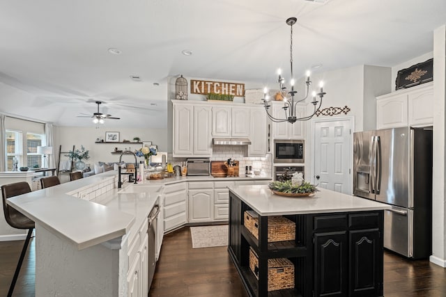 416 Springhill Dr, Hurst, TX 76054 - kitchen with appliances with stainless steel finishes, a peninsula, dark wood-type flooring, white cabinetry, and recessed lighting