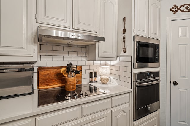 416 Springhill Dr, Hurst, TX 76054 - kitchen with oven, built in microwave, under cabinet range hood, black electric cooktop, and white cabinetry