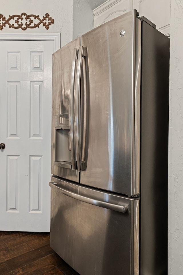 416 Springhill Dr, Hurst, TX 76054 - kitchen view of stainless steel fridge, dark wood-type flooring, a textured wall, and white cabinetry