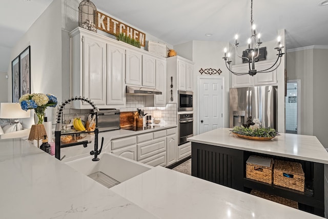 416 Springhill Dr, Hurst, TX 76054 - kitchen featuring stainless steel appliances, under cabinet range hood, backsplash, a chandelier, and white cabinetry
