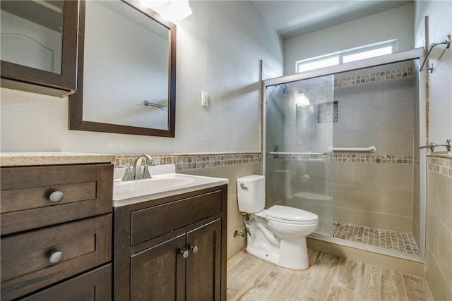 1300 Meadow Ranch Rd, Mckinney, TX 75071 - bathroom with tile walls, vanity, a stall shower, wood finished floors, and a wainscoted wall