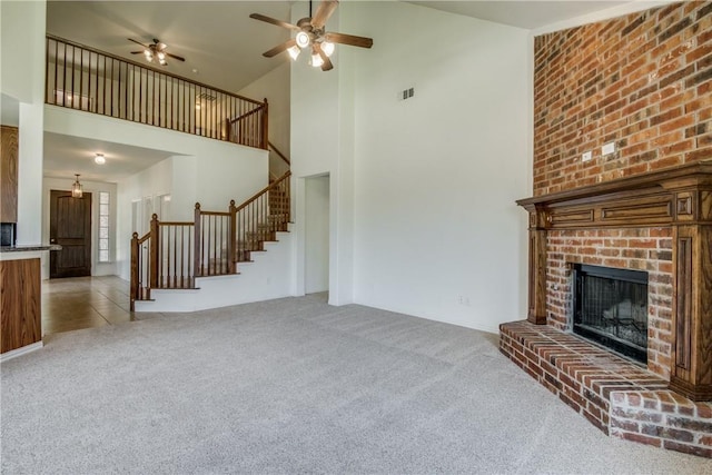 1300 Meadow Ranch Rd, Mckinney, TX 75071 - unfurnished living room featuring carpet flooring, stairs, high vaulted ceiling, ceiling fan, and a brick fireplace