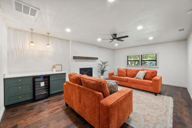 1205 Columbia Cir, Corsicana, TX 75110 - living area with wine cooler, dark wood-type flooring, a bar, ceiling fan, and a fireplace