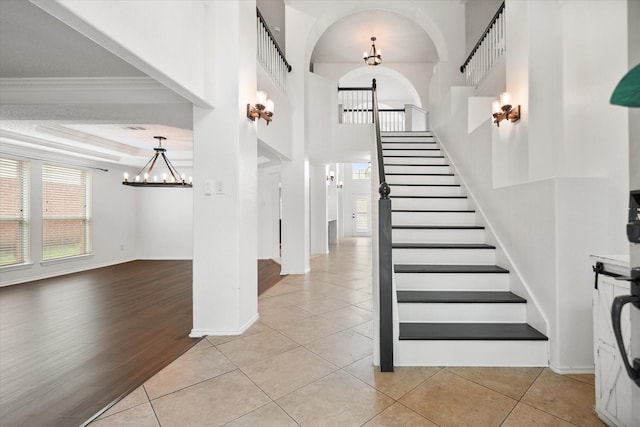 4412 Corner Brook Ln, Fort Worth, TX 76123 - stairway featuring a chandelier, tile patterned flooring, and arched walkways
