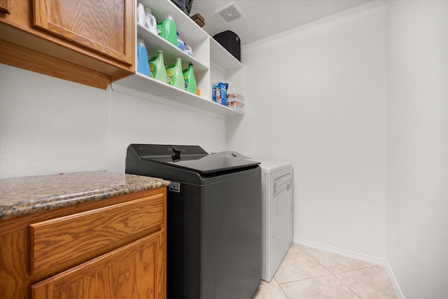 4412 Corner Brook Ln, Fort Worth, TX 76123 - washroom featuring separate washer and dryer, cabinet space, and light tile patterned floors