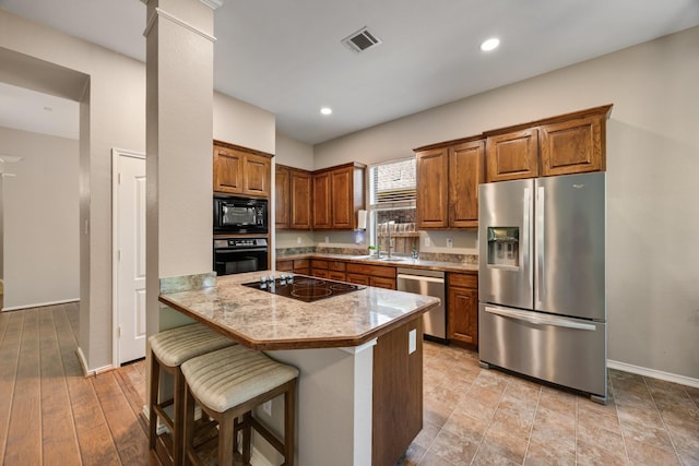 2823 Coteau Way, Dallas, TX 75227 - kitchen featuring black appliances, brown cabinetry, a kitchen breakfast bar, light countertops, and recessed lighting