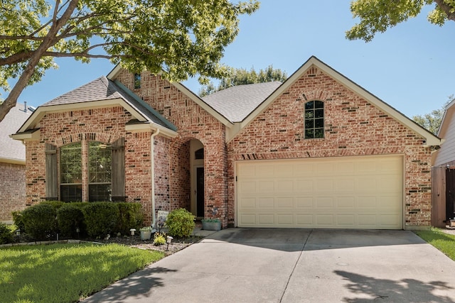 2823 Coteau Way, Dallas, TX 75227 - view of front facade featuring brick siding, driveway, an attached garage, and a shingled roof