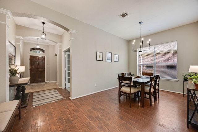 2823 Coteau Way, Dallas, TX 75227 - dining space with arched walkways, dark wood-style flooring, and a chandelier
