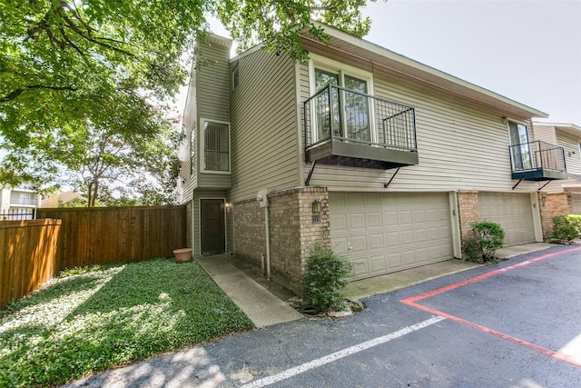 7450 Holly Hill Dr Unit 115, Dallas, TX 75231 - view of side of property with a balcony, brick siding, an attached garage, and a chimney
