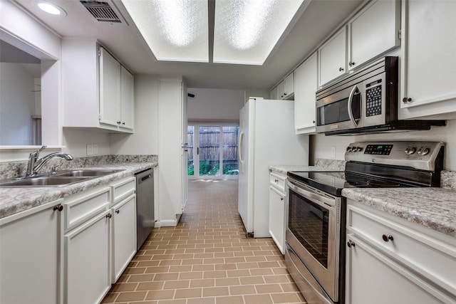 7450 Holly Hill Dr Unit 115, Dallas, TX 75231 - kitchen featuring appliances with stainless steel finishes, light countertops, and white cabinets
