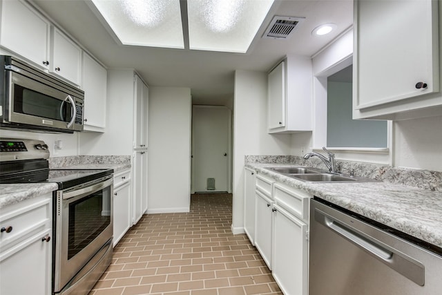 7450 Holly Hill Dr Unit 115, Dallas, TX 75231 - kitchen with stainless steel appliances, light countertops, white cabinets, and recessed lighting