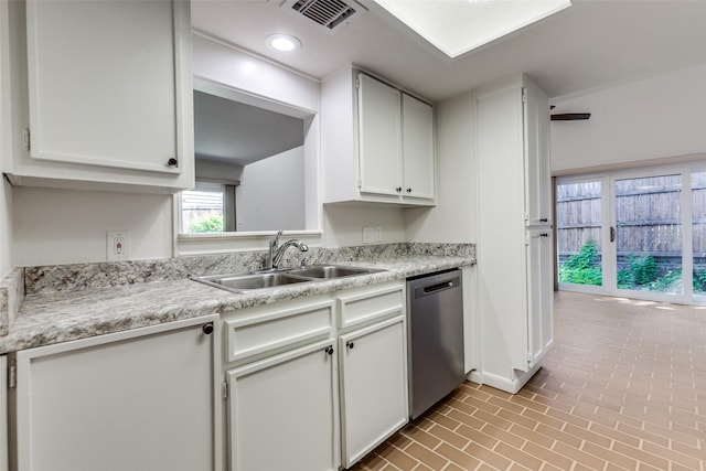 7450 Holly Hill Dr Unit 115, Dallas, TX 75231 - kitchen with dishwasher, light countertops, white cabinets, brick patterned floors, and recessed lighting