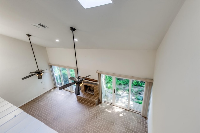 7450 Holly Hill Dr Unit 115, Dallas, TX 75231 - unfurnished living room featuring high vaulted ceiling, a skylight, recessed lighting, a ceiling fan, and a brick fireplace