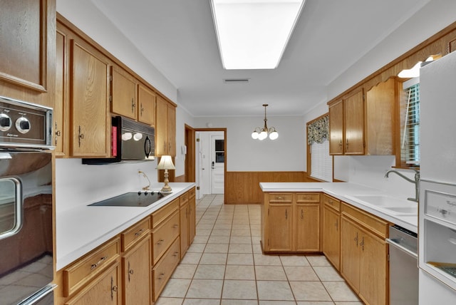 824 Captain Shreve Dr, Shreveport, LA 71105 - kitchen with black appliances, a chandelier, light countertops, wainscoting, and a peninsula