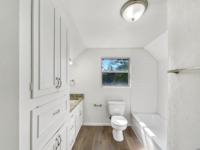 5941 Ten Mile Bridge Rd, Fort Worth, TX 76135 - bathroom featuring wood finished floors, vanity, lofted ceiling, a textured wall, and shower / washtub combination