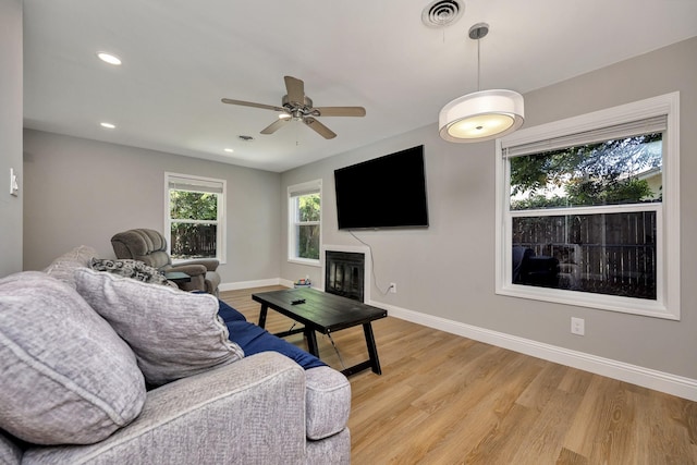 5125 Susan Lee Ln, North Richland Hills, TX 76180 - living room with light wood-type flooring, ceiling fan, a glass covered fireplace, and recessed lighting