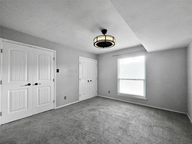 6620 Eastridge Dr Unit 219, Dallas, TX 75231 - unfurnished bedroom featuring carpet, multiple closets, and a textured ceiling