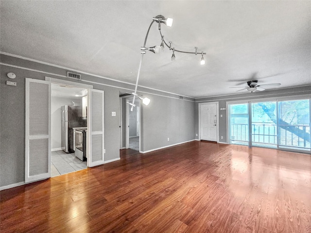 6620 Eastridge Dr Unit 219, Dallas, TX 75231 - unfurnished living room featuring a ceiling fan, wood finished floors, and crown molding