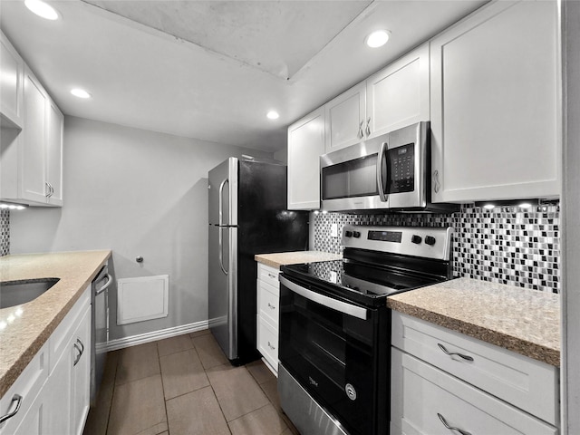 6620 Eastridge Dr Unit 219, Dallas, TX 75231 - kitchen with stainless steel appliances, recessed lighting, backsplash, white cabinets, and light stone counters