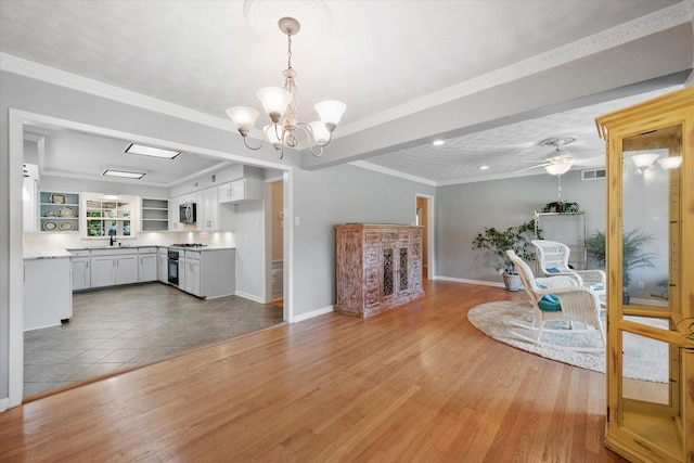 1215 Columbia Cir, Corsicana, TX 75110 - living area with a chandelier, light wood finished floors, crown molding, and ceiling fan