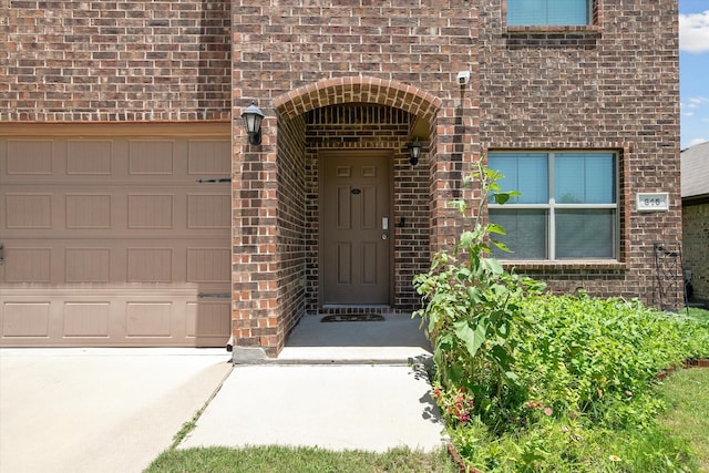 616 Cameron Way, Azle, TX 76020 - view of exterior entry featuring brick siding, a garage, and driveway