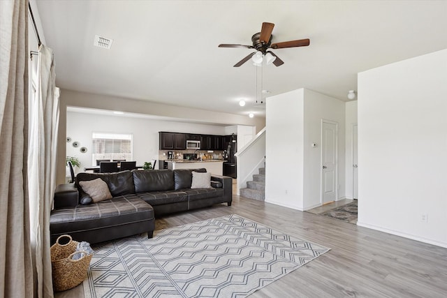 616 Cameron Way, Azle, TX 76020 - living room with stairs, a ceiling fan, and light wood-type flooring
