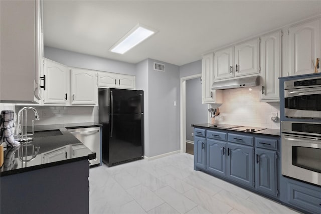 3122 Old Orchard Rd, Garland, TX 75041 - kitchen featuring stainless steel appliances, dark countertops, under cabinet range hood, white cabinetry, and blue cabinetry