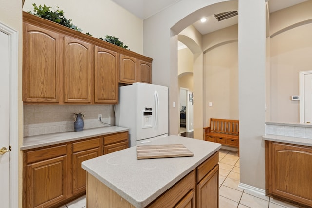 5606 Bay Meadows Dr, Frisco, TX 75034 - kitchen featuring white refrigerator with ice dispenser, arched walkways, decorative backsplash, light countertops, and light tile patterned flooring