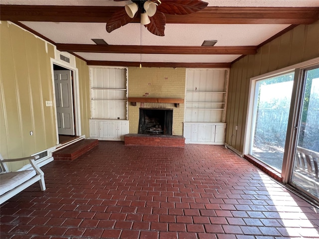 2928 Pine Ave, Waco, TX 76708 - unfurnished living room with beam ceiling, ceiling fan, wooden walls, a fireplace, and crown molding