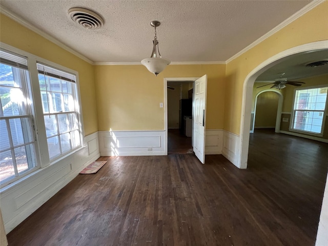 2928 Pine Ave, Waco, TX 76708 - unfurnished dining area with arched walkways, dark wood-type flooring, a textured ceiling, wainscoting, and crown molding