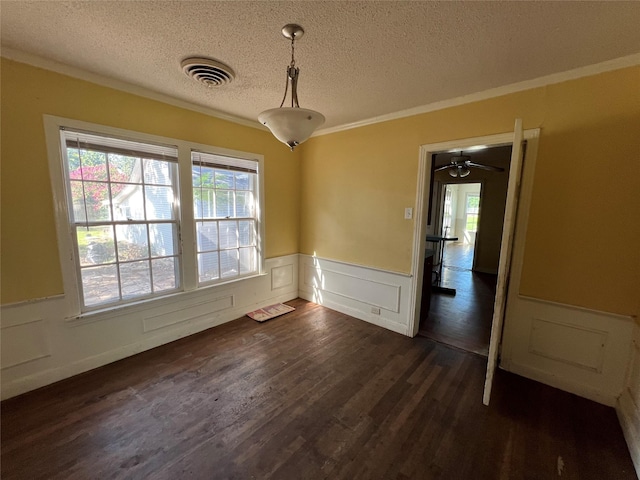 2928 Pine Ave, Waco, TX 76708 - unfurnished dining area with a wainscoted wall, a textured ceiling, plenty of natural light, crown molding, and dark wood finished floors