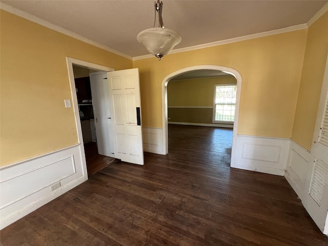 2928 Pine Ave, Waco, TX 76708 - spare room featuring arched walkways, crown molding, wainscoting, dark wood-style floors, and a textured ceiling