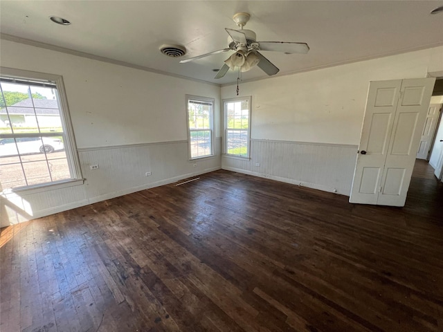 2928 Pine Ave, Waco, TX 76708 - unfurnished room with wainscoting, dark wood-style floors, ceiling fan, healthy amount of natural light, and crown molding