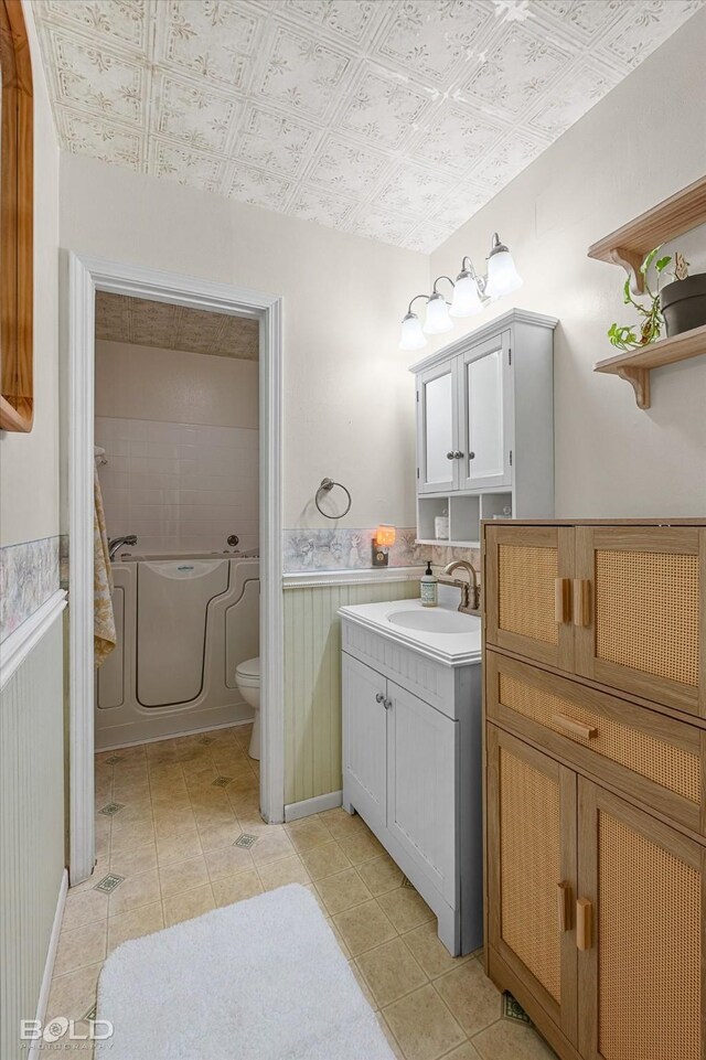 110 Elmview Ln, Haughton, LA 71037 - bathroom with vanity, an ornate ceiling, tile patterned flooring, wainscoting, and a tub