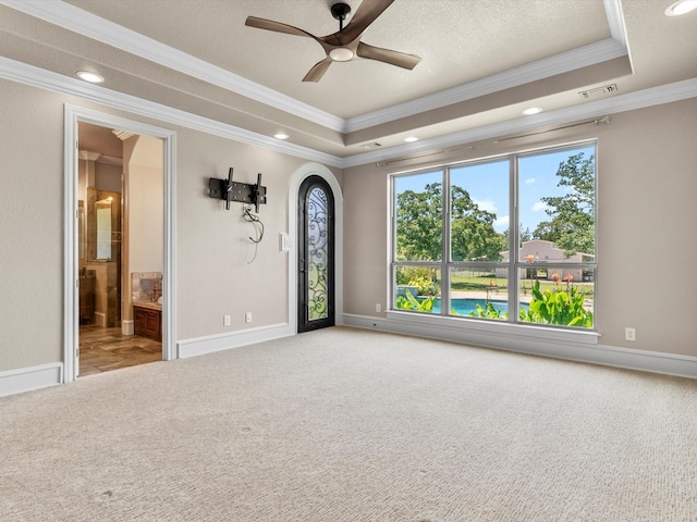 830 Cemetery Rd, Decatur, TX 76234 - carpeted spare room featuring ornamental molding, a tray ceiling, a ceiling fan, recessed lighting, and arched walkways