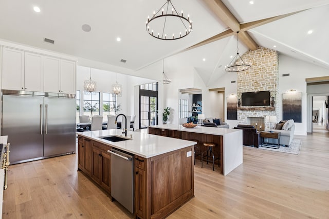 1890 Mcconnell Rd, Gunter, TX 75058 - kitchen with appliances with stainless steel finishes, a spacious island, a chandelier, beamed ceiling, and light wood finished floors