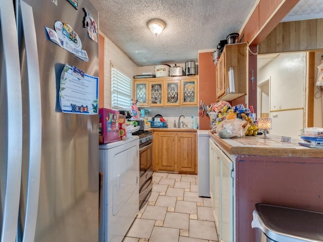 1405 NE 37th St, Fort Worth, TX 76106 - kitchen with fridge, tile countertops, washer / dryer, and a textured ceiling