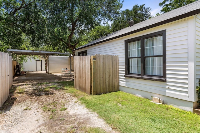 1204 Maxfield St, Bellmead, TX 76705 - view of yard featuring driveway, a storage unit, and a carport