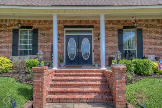 133 Downs Dr, Benton, LA 71006 - property entrance with a porch, roof with shingles, and brick siding