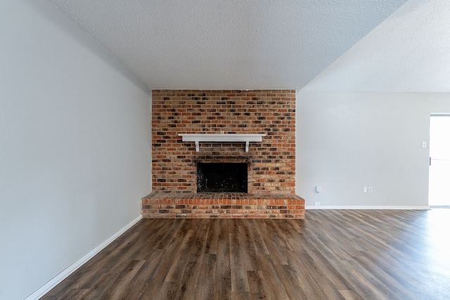 5209 Wolens Way, Fort Worth, TX 76133 - unfurnished living room featuring wood finished floors, a textured ceiling, and a fireplace