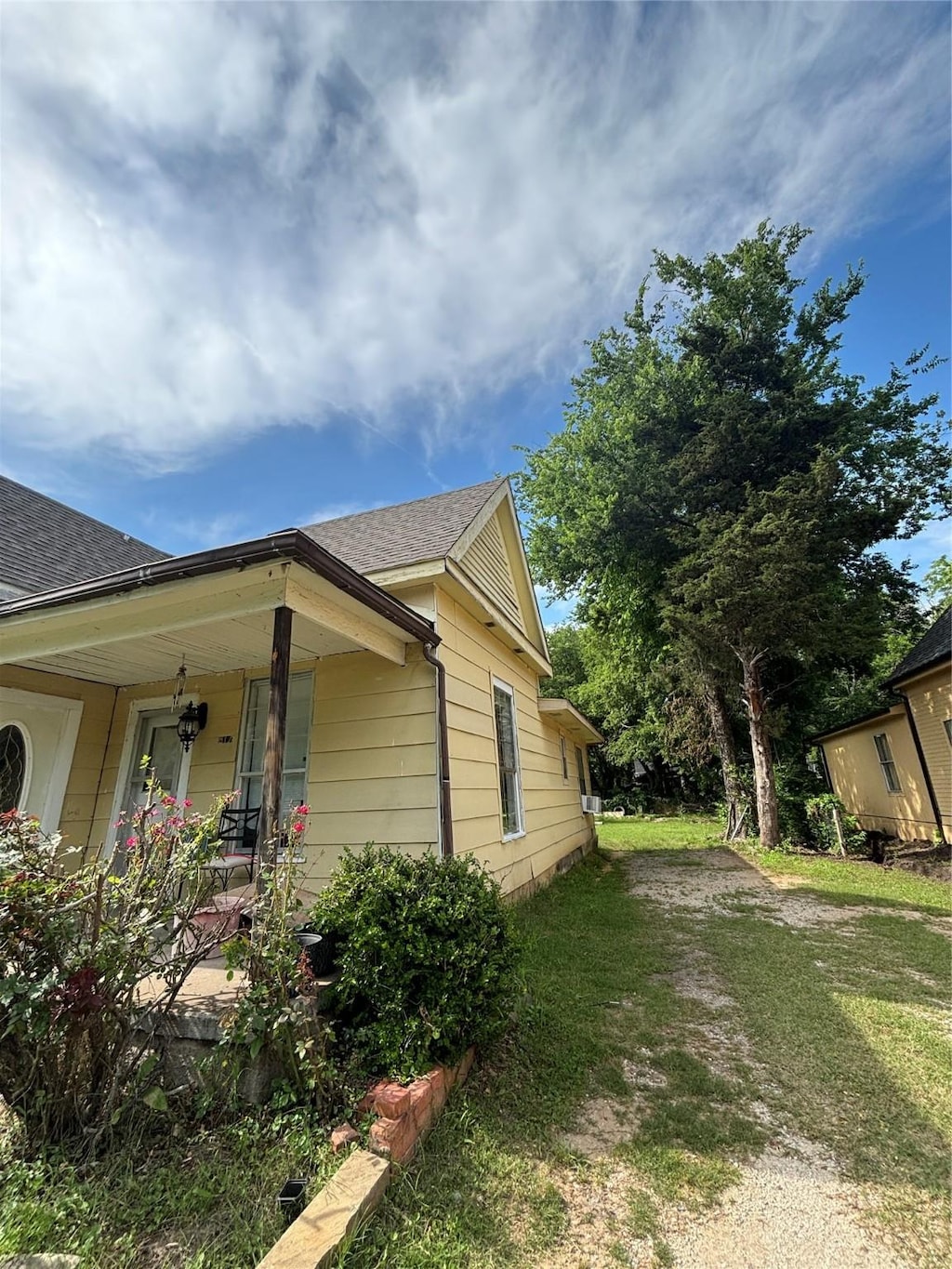 817 W Ellis St, Sherman, TX 75092 - view of property exterior with a porch, roof with shingles, and a yard